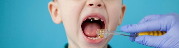 Little cute boy brushing his teeth on blue background