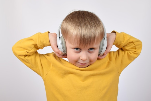 little cute boy child listening to music in headphones