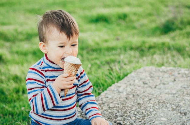 Маленький милый мальчик ест мороженое