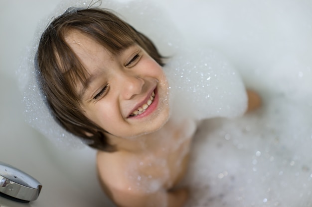 Piccolo ragazzo carino con bagnoschiuma