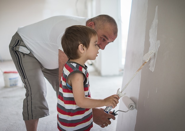 Little cute boy painting on a wall