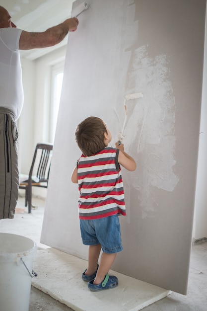 Little cute boy painting on a wall