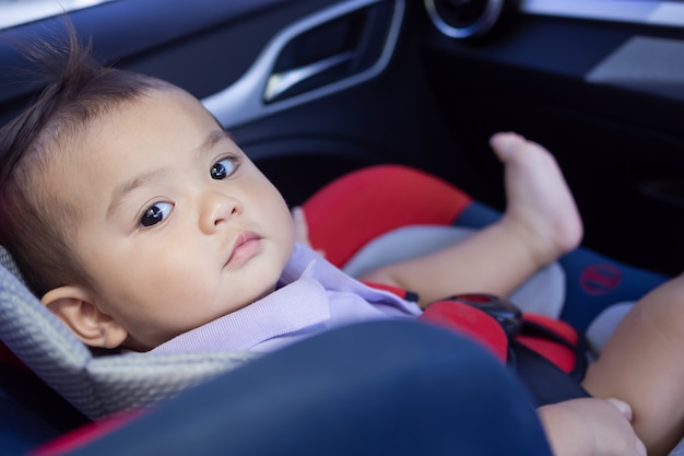 車に座っている小さなかわいい男の子が車に座っています。