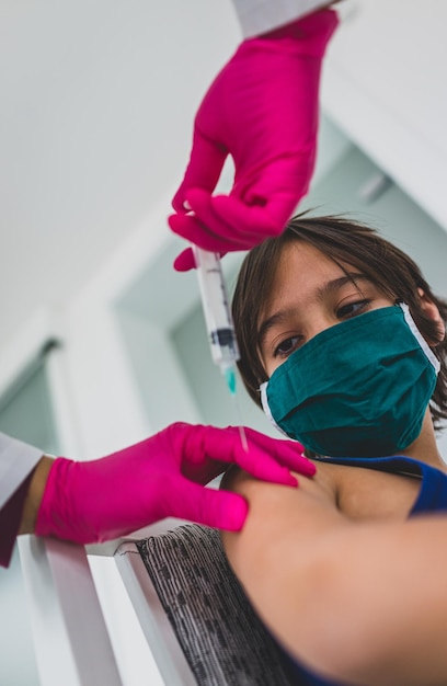 Little cute child with mask getting injection shot