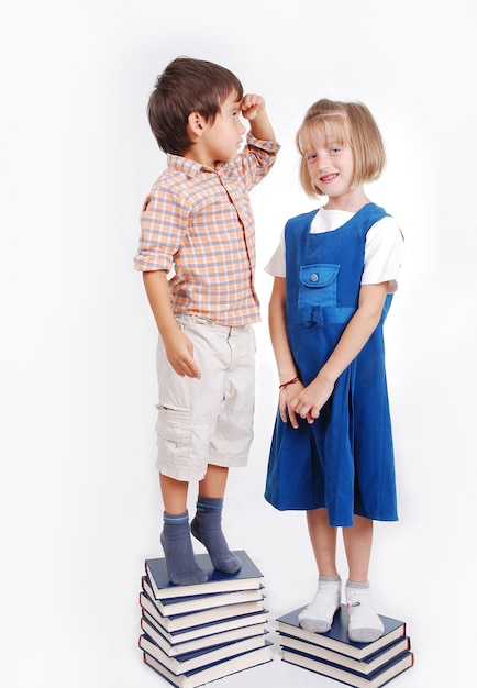 Little cute girl and boy with many books isolated