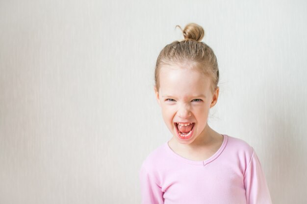 Little cute girl depicts emotions. Scream, anger, rage, wild