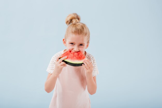 スイカのスライスを食べるかわいい女の子