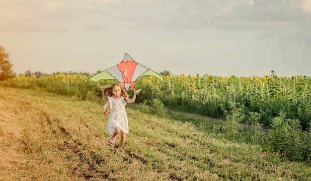 Little cute girl flying a kite