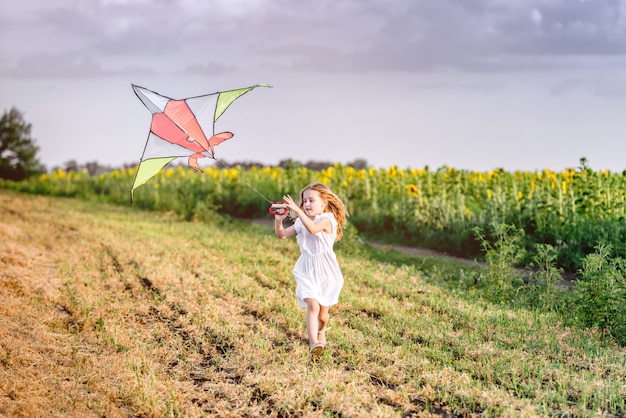 Little cute girl flying a kite