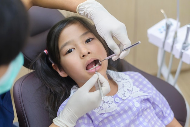 A little cute girl having teeth examined by dentist in dental clinic teeth checkup and Healthy teeth concept