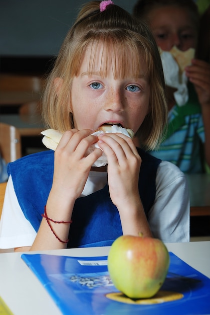 Фото Маленькая милая девушка в классе, едят