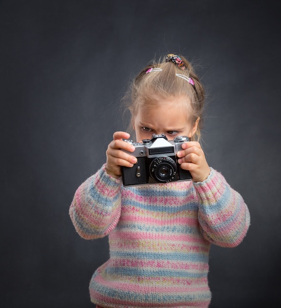 Little cute girl looks photos at the camera