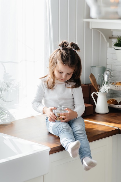 Little cute girl playing in the kitchen, happiness, family. Cooking.