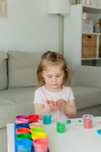 Little cute girl sculpts from colored plasticine. 