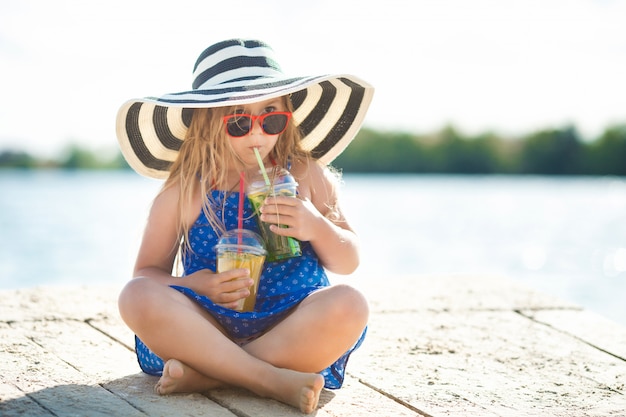 海の上のかわいい女の子。夏には帽子の少女。海岸線で愛らしい子。