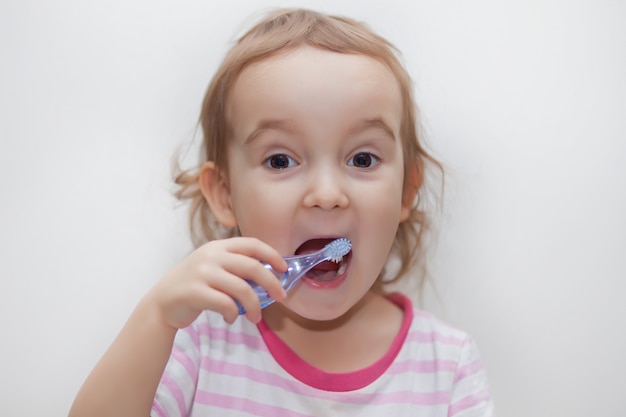 Little cute girl smailing and brushing her teeth.