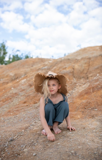 Little cute girl in stylish clothes in a nature scenery