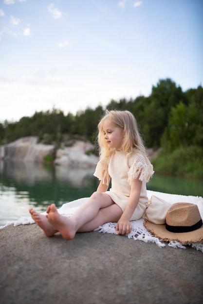 Bambina carina in vestiti alla moda in uno scenario naturale