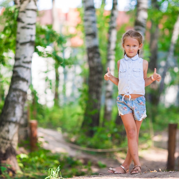 Little cute girl in summer park outdoors