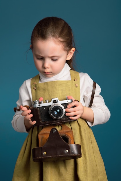 小さなかわいい女の子は、カメラの設定を理解しようとします