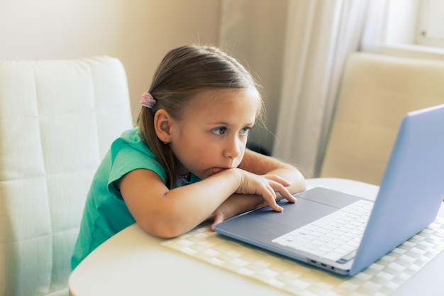 Little cute girl uses laptop to have video call