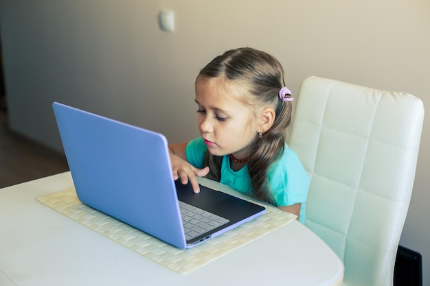 Foto la ragazzina carina usa il laptop per fare una videochiamata