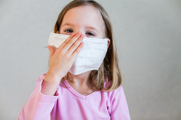 Little cute girl in a white medical mask