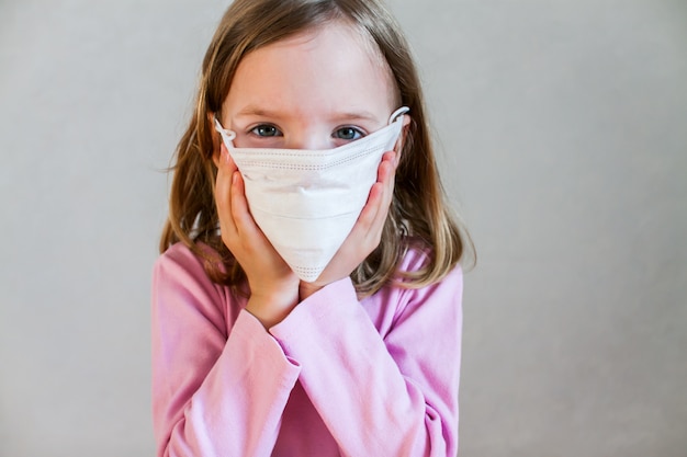 Little cute girl in a white medical mask