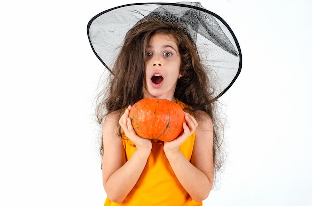 Photo little cute girl in a witch hat broom pumpkin heluin place for text