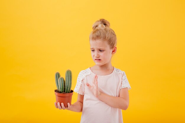 Little cute girl with a cactus in a pot