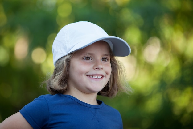 Foto piccola ragazza carina con un berretto nel parco