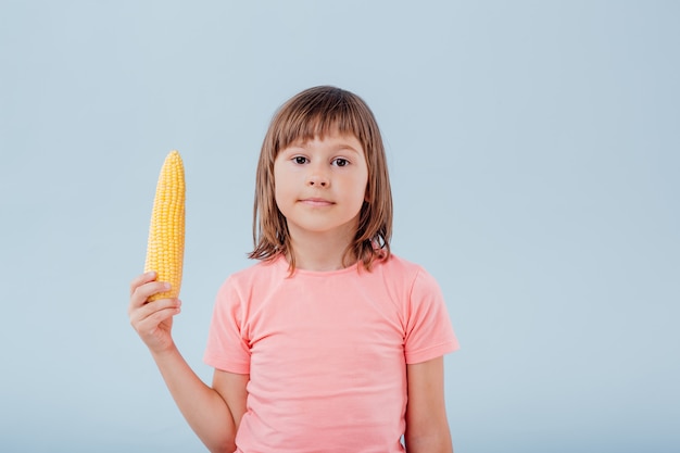 Little cute girl with a corn ear