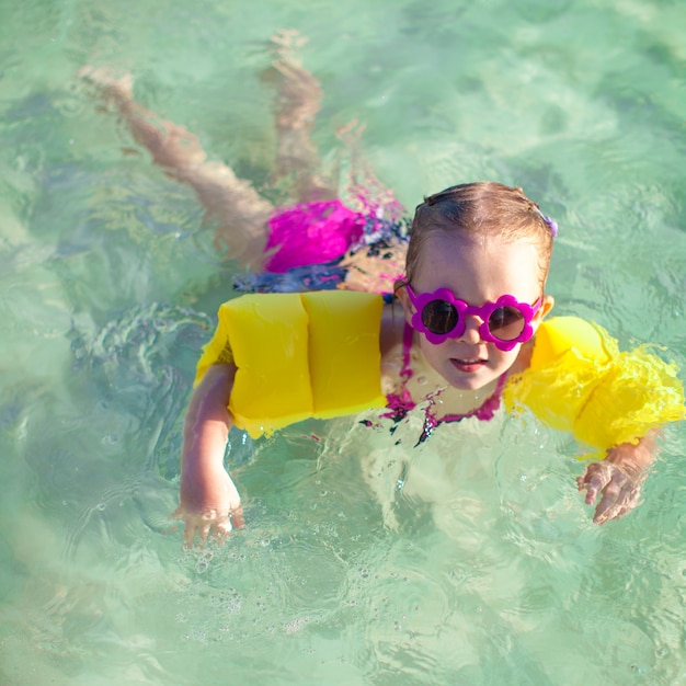 Little cute girl with diving in the sea in nice sunglasses