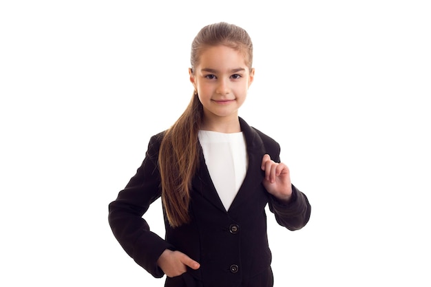 Little cute girl with long brown ponytail in white Tshirt and black jacket on white background