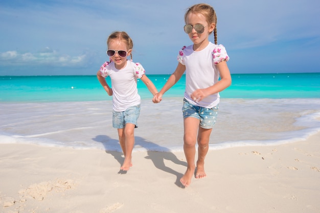 Photo little cute girls enjoy their summer vacation on the beach