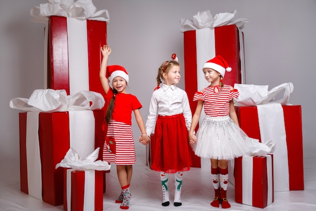 Маленькие милые девушки в студии с украшениями и реквизитом зимнего праздника.