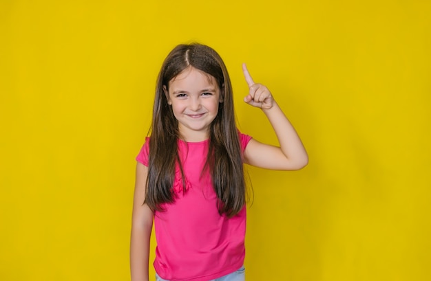 A little cute happy girl looking and showing a gesture indicating an idea.