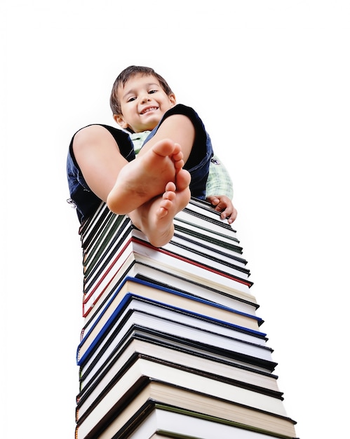 A little cute kid and large number of books as a tower