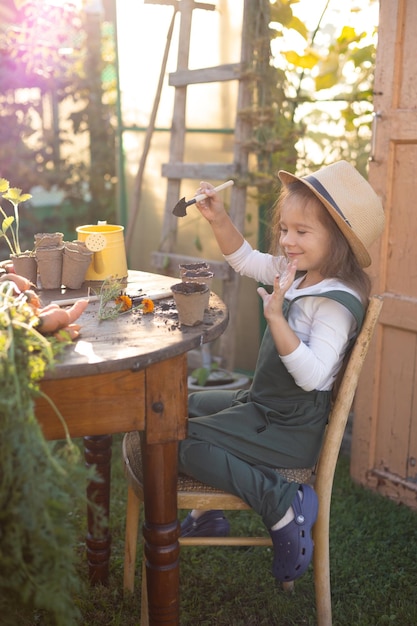 A little cute longhaired farmer girl is engaged in planting plants Village vegetable garden gardening Ecology