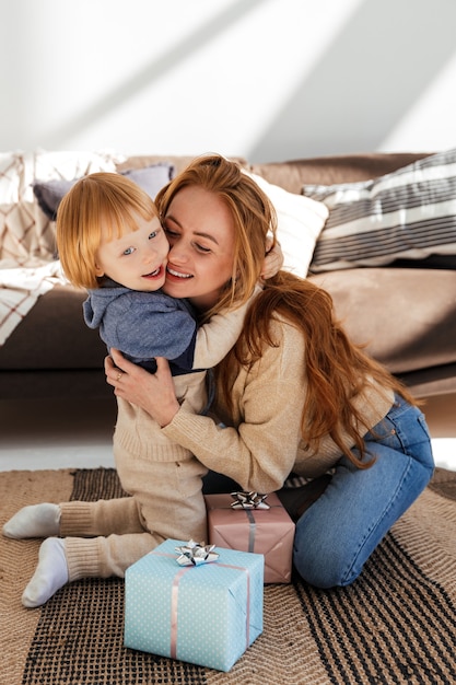 Little cute red haired boy gives mom a new year gift