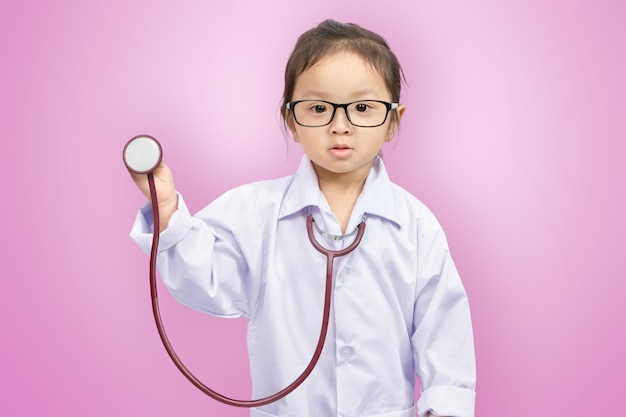 A little cute smiling girl in doctor uniform with stethoscope