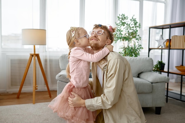幸せな笑顔の父にキスをする小さな娘
