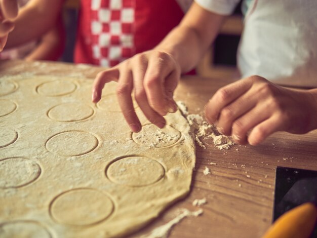 写真 自宅のキッチンで一緒に料理をする小さな娘。幸せな家族とライフスタイルのコンセプト。