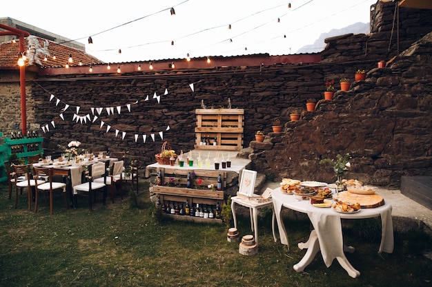 Foto piccolo tavolo da pranzo servito in stile rustico e decorato con fiori rosa si trova all'esterno