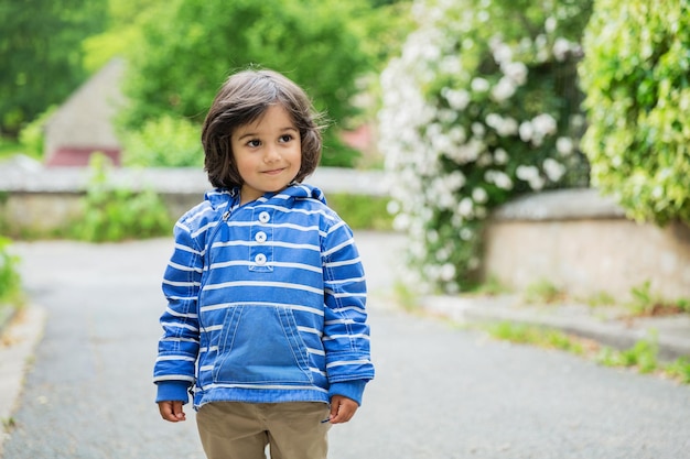 Little eastern handsome baby boy staying outdoor in old town in France