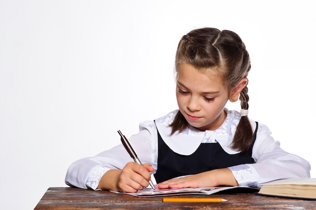 Little European school girl student posing in studio.