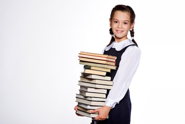 Little European school girl student posing in studio