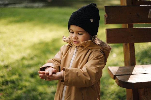 Little female kid eating chocolate pancake outdoor autumn mood