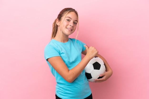 Little football player girl isolated on pink background proud and self-satisfied