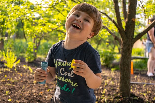 Little four years boy blow soap bubbles, outdoors, summer, happy boy